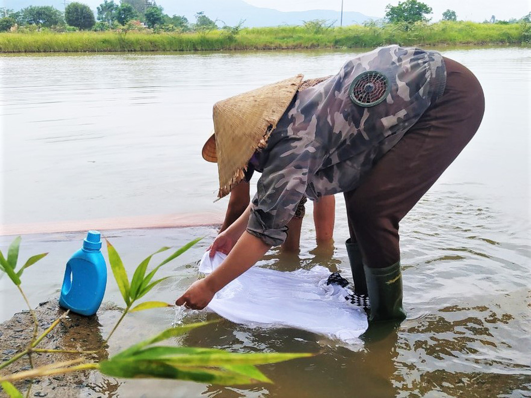 Do thiếu nguồn nước sinh hoạt nên người dân xã Thuận Lộc phải mang áo quần ra kênh giặt giũ - Ảnh: L.M.
